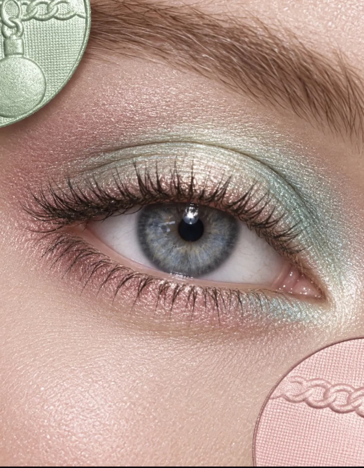Blue eye with pastel shimmer eyeshadow blending mint green across the lid into peachy pink on the inner and outer corners.