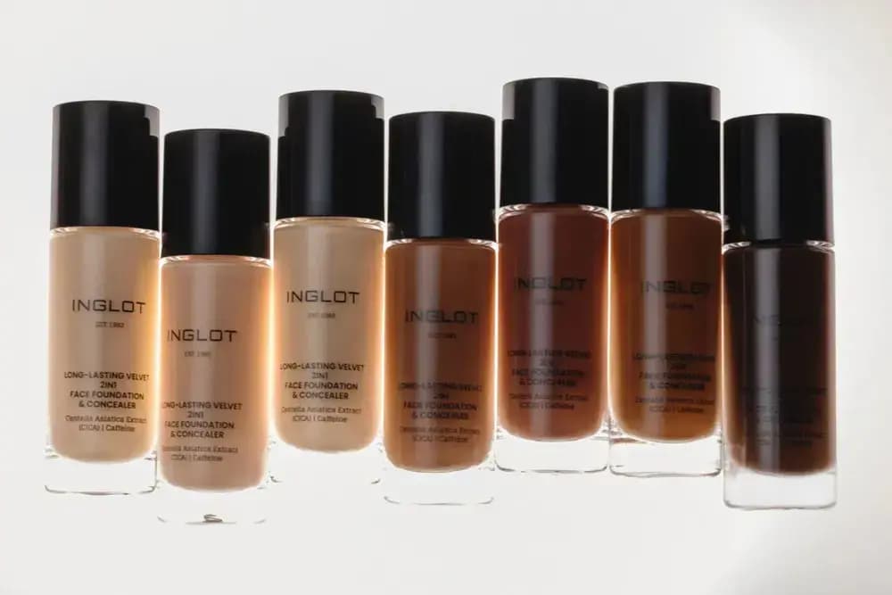 Seven bottles with black caps in a row, shades shifting from light beige to deep brown