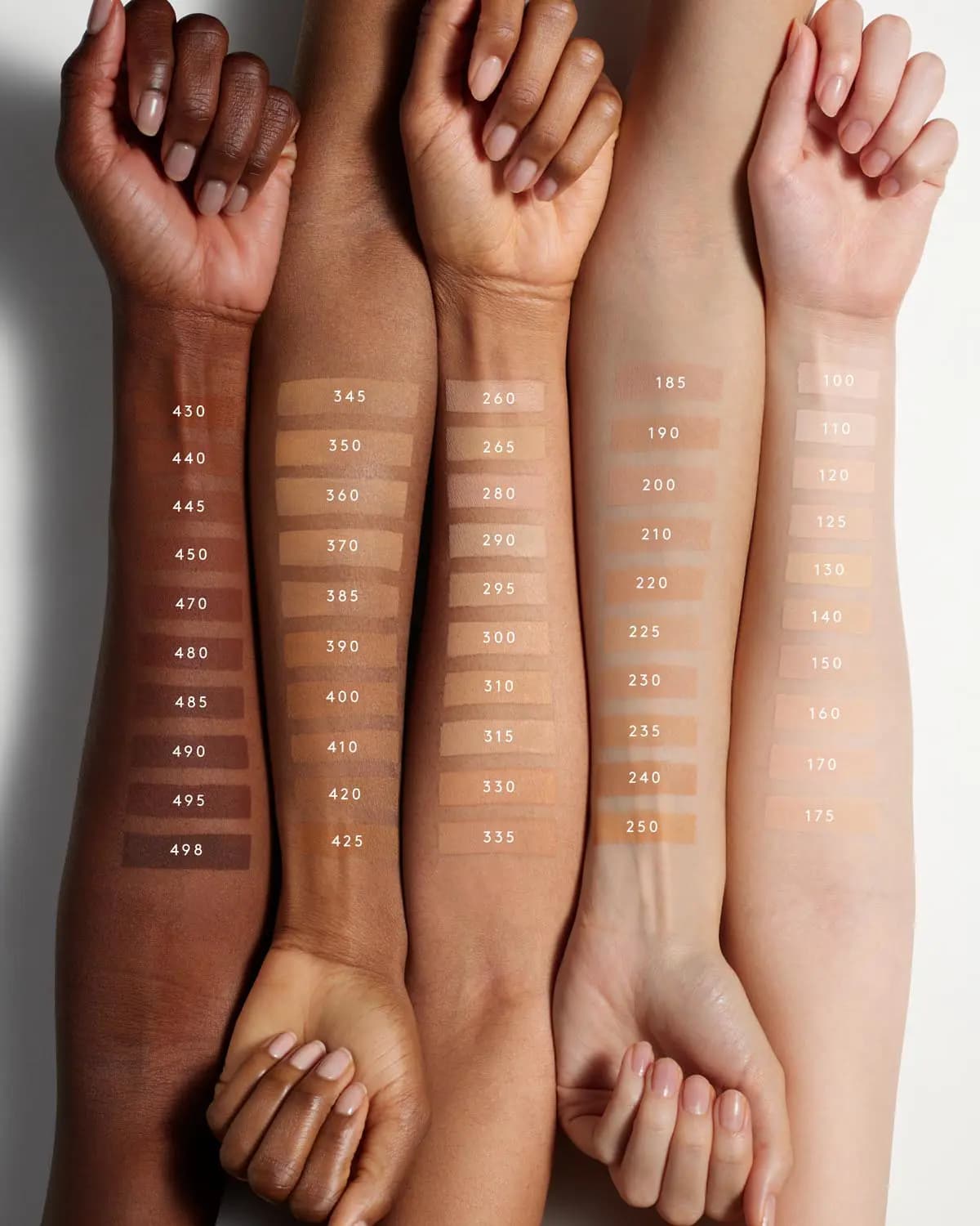 Five arms from deep to fair skin tones with numbered foundation swatches running from shade 100 to 498