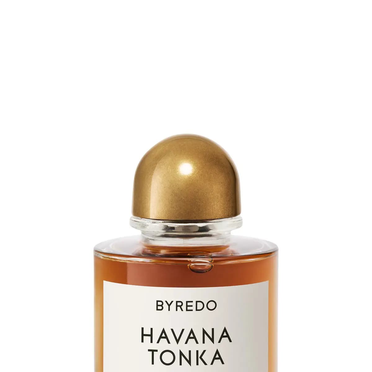 Close-up of the Havana Tonka bottle's domed brushed-gold cap, clear glass neck and top of the white label