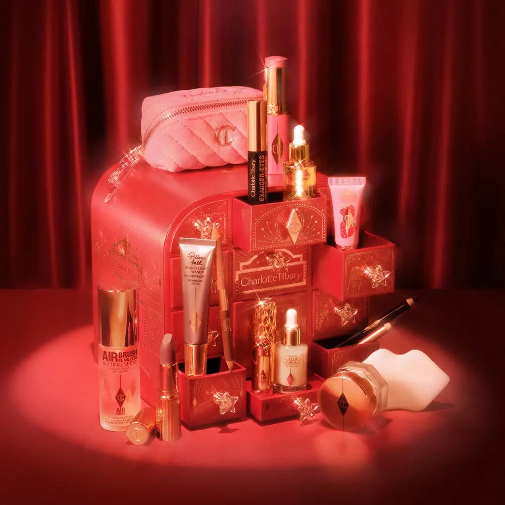 Red Charlotte Tilbury advent calendar with open drawers showing Airbrush Flawless spray, Exagger-Eyes mascara and more