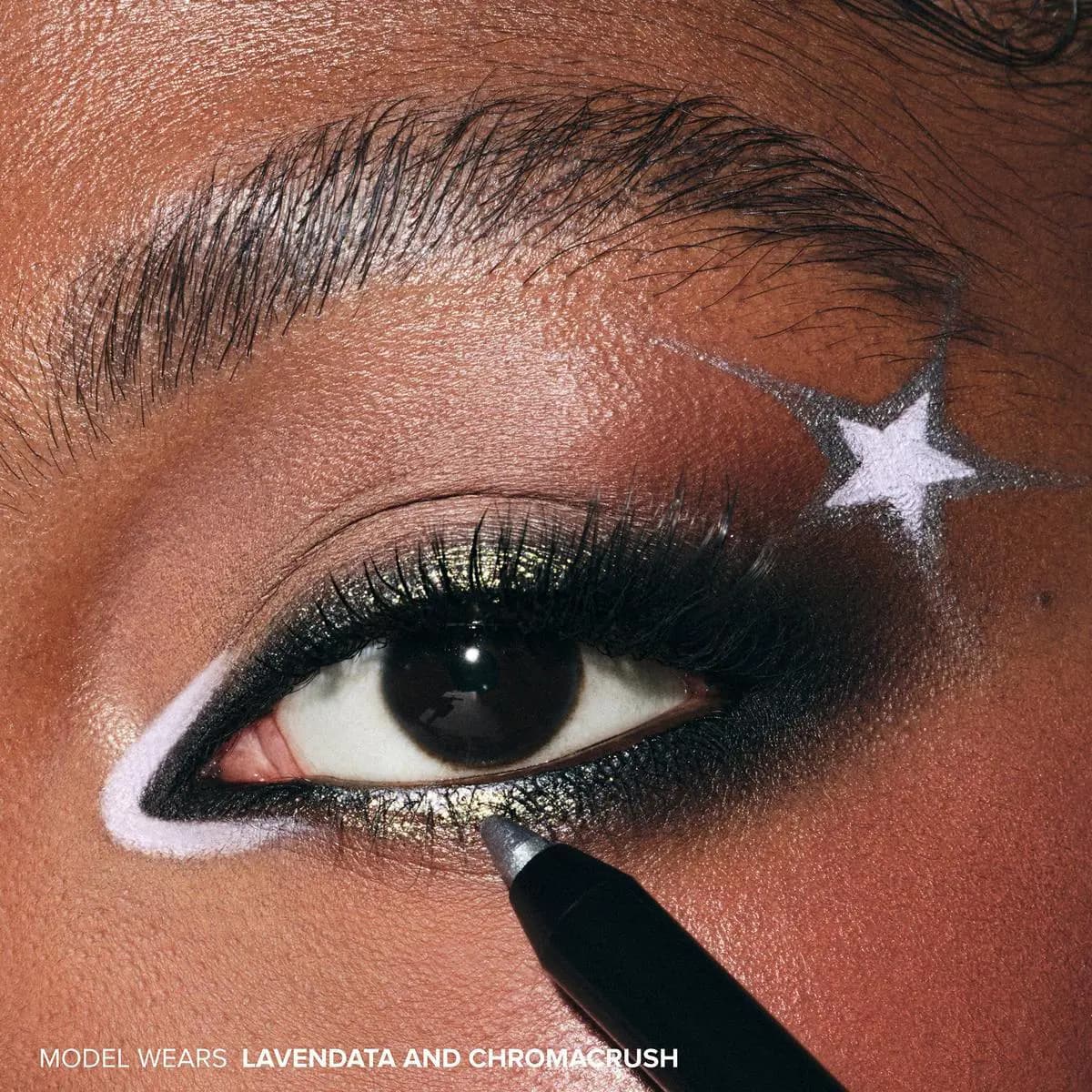Close-up of a brown eye with black smoky liner, white star accent and pale lavender inner rim being applied with a pencil