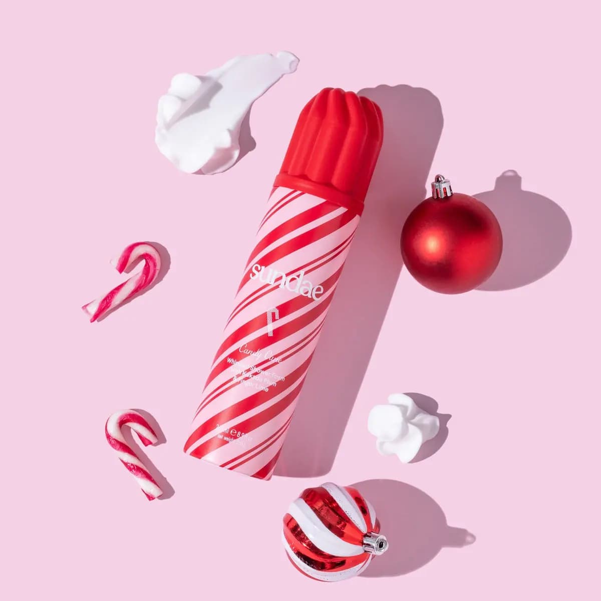 Red and pink striped Candy Cane can with candy canes, red baubles and white foam on pink