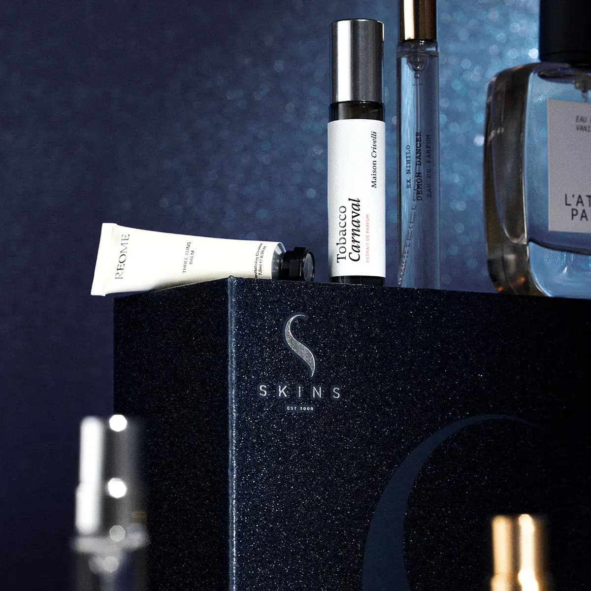 Close-up of Reome Three Suns Balm, Maison Crivelli Tobacco Carnaval and Ex Nihilo Demon Dancer on the Skins box