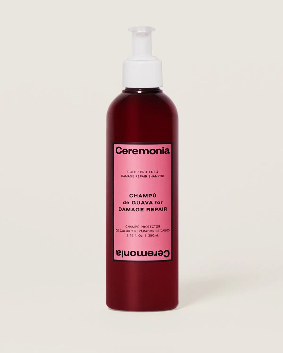 Ceremonia Champú de Guava for Damage Repair shampoo in a dark red pump bottle with pink label on a cream background