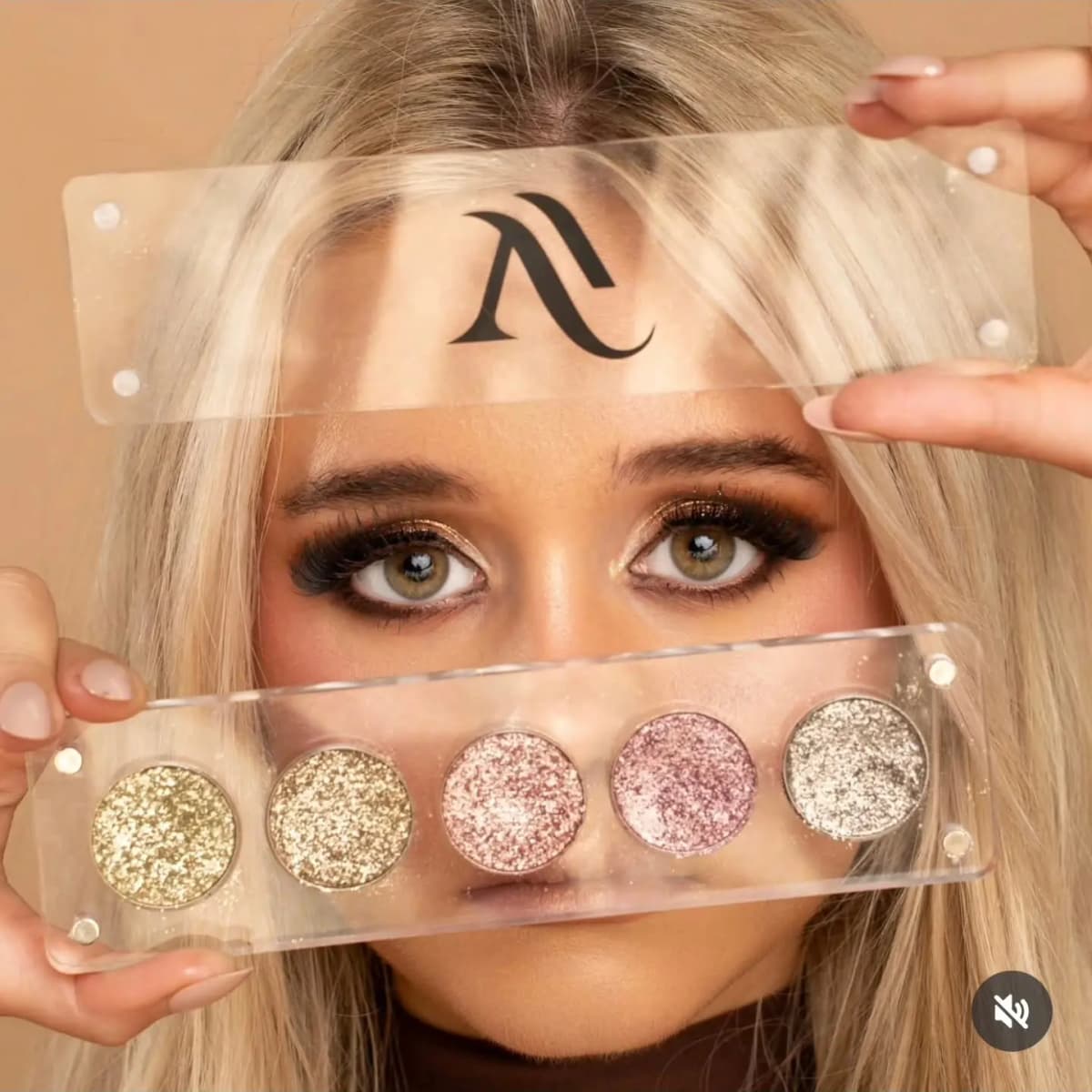 Model peeks between a clear palette lid and a five-pan base of gold, pink and silver foiled metallic shimmer shadows.