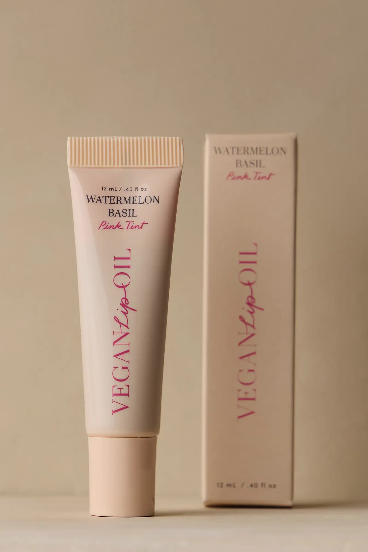 Cream Vegan Lip Oil tube in Watermelon Basil Pink Tint, 12 mL, beside its matching beige box