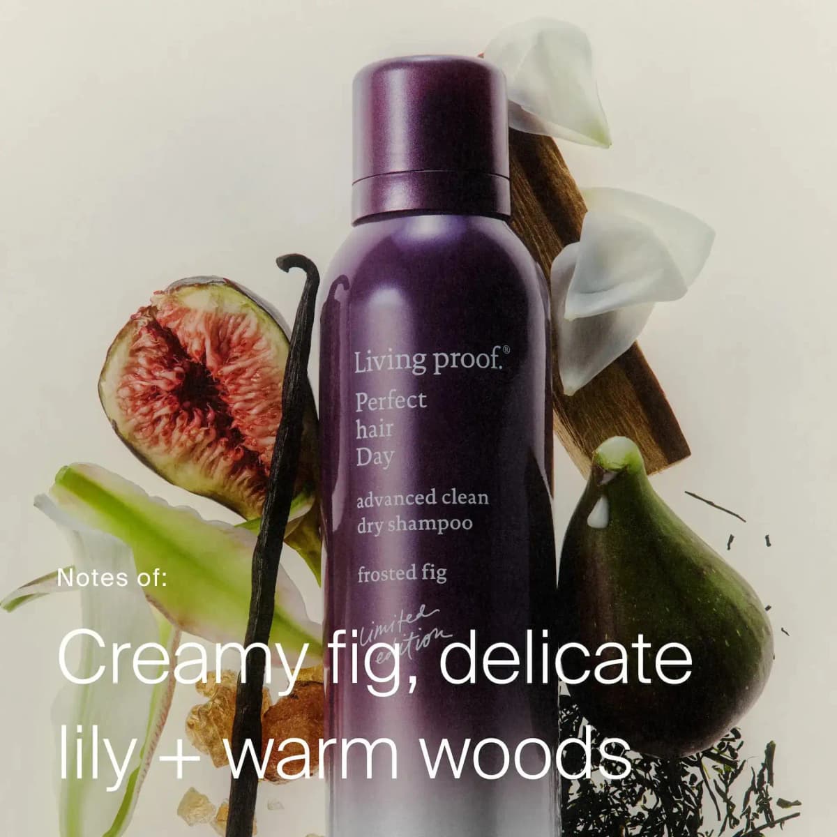 Frosted Fig dry shampoo surrounded by halved figs, vanilla pod, white lily petals and wood, with scent notes text