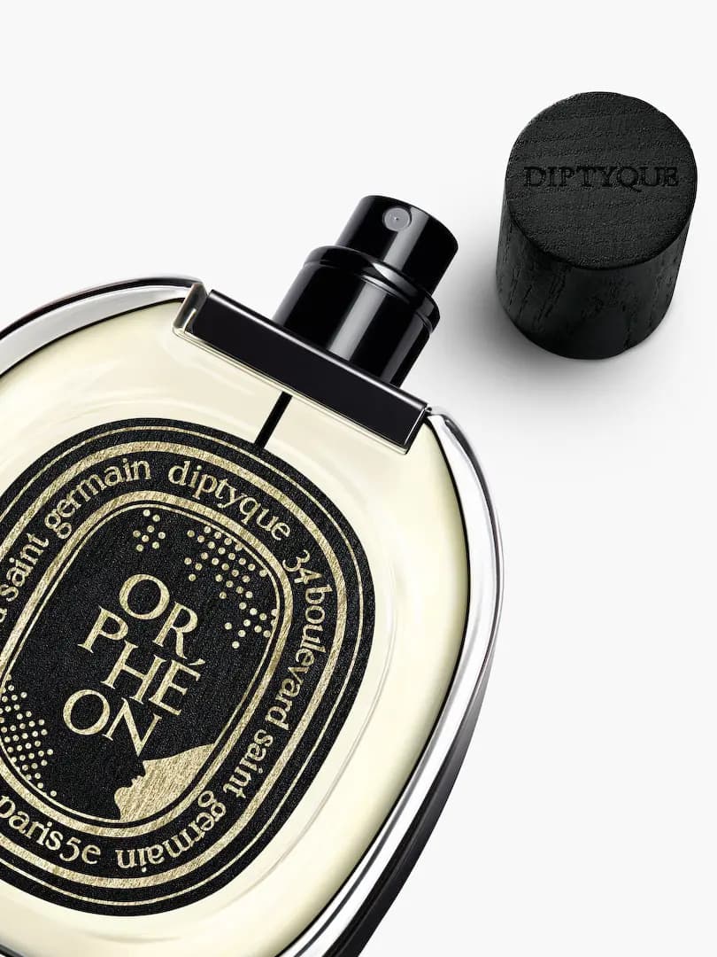 Close-up of uncapped Orphéon bottle showing gold dot pattern label and embossed wooden cap