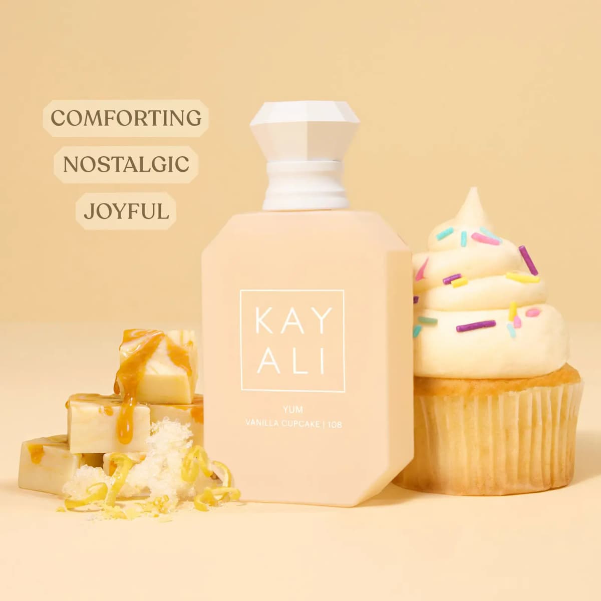 Bottle between caramel-drizzled fudge and a sprinkle-topped vanilla cupcake, labelled comforting, nostalgic, joyful