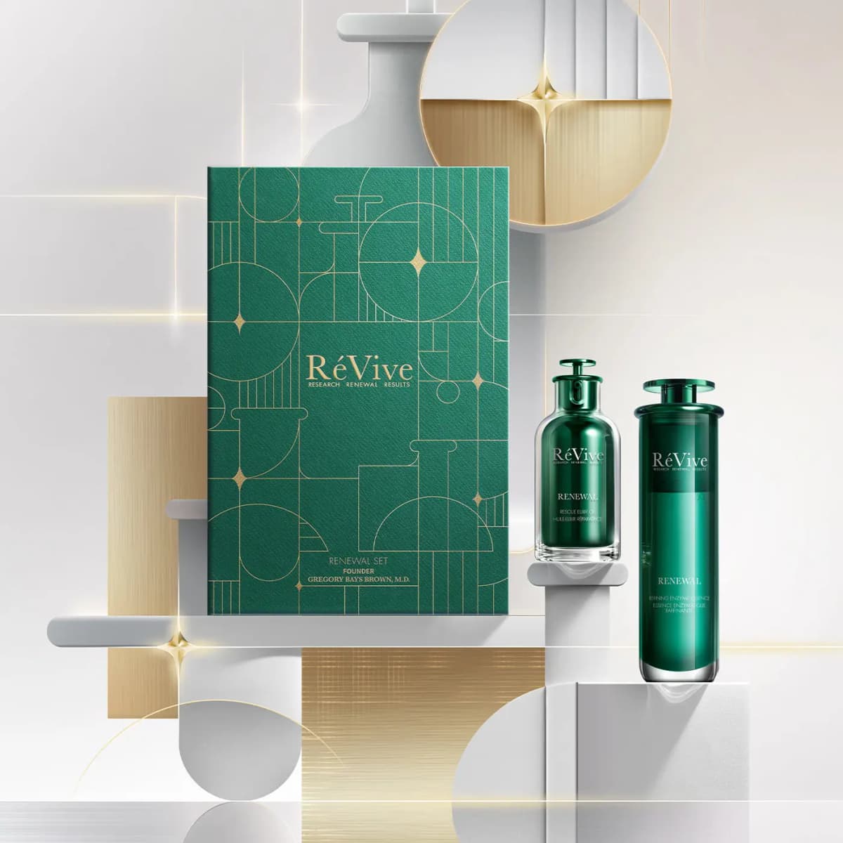 Renewal Set box with elixir oil and enzyme essence bottles on white plinths before gold and silver shapes