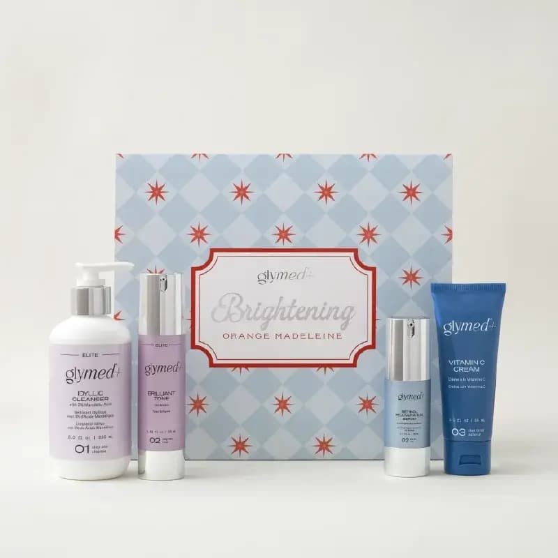 GlyMed+ Brightening Orange Madeleine set: Idyllic Cleanser, toner, serum and Vitamin C Cream before a harlequin box