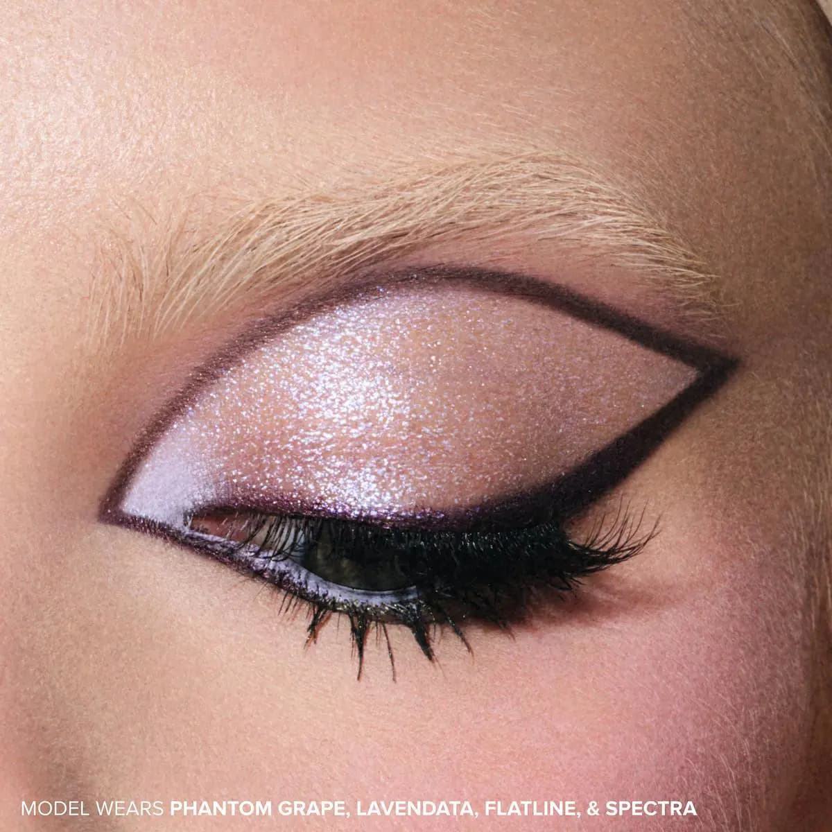 Close-up of a closed eye with shimmery lavender lid and dark plum graphic winged liner, labeled Phantom Grape, Lavendata