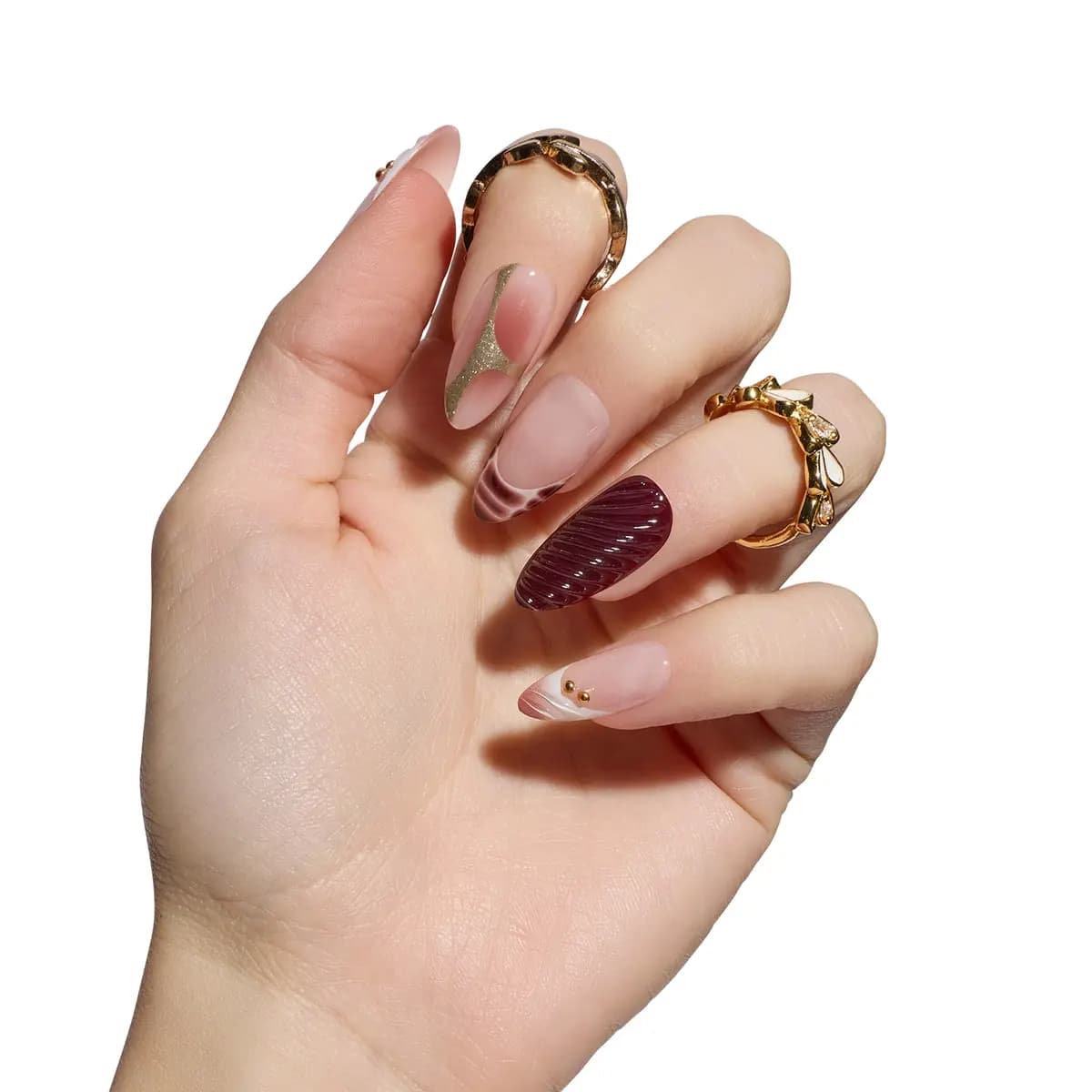 Hand wearing Mauve Mirage almond nails: textured plum swirl, mauve-striped French tip, gold glitter line and gold studs.