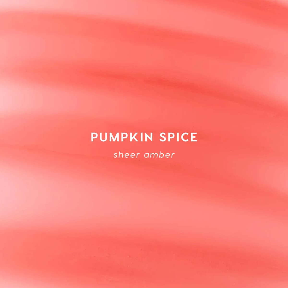 Smeared swatch of Pumpkin Spice balm in sheer coral-amber, labelled with the shade name and "sheer amber