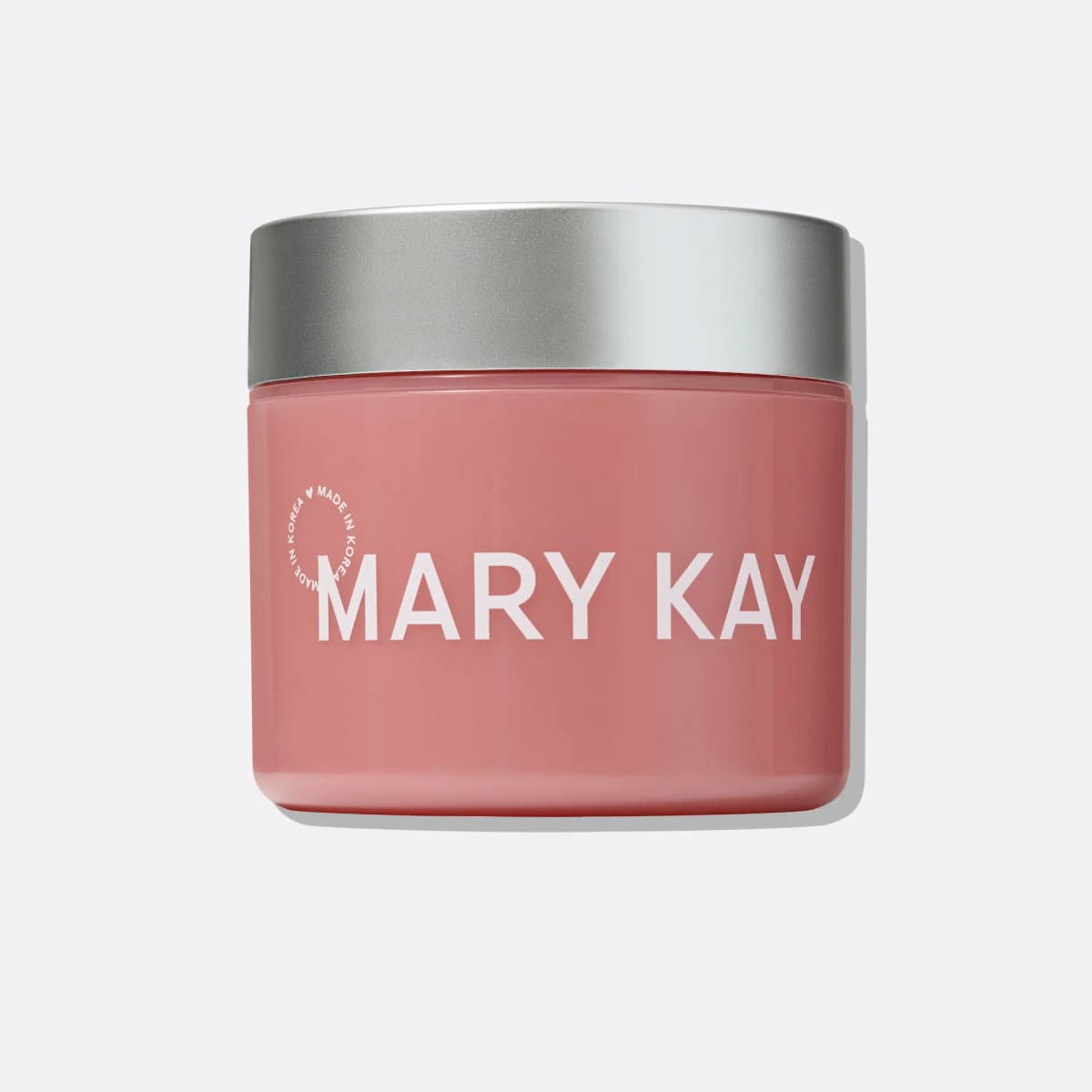 Pink Mary Kay jar with a brushed silver lid and white logo, made in Korea, on a light grey background