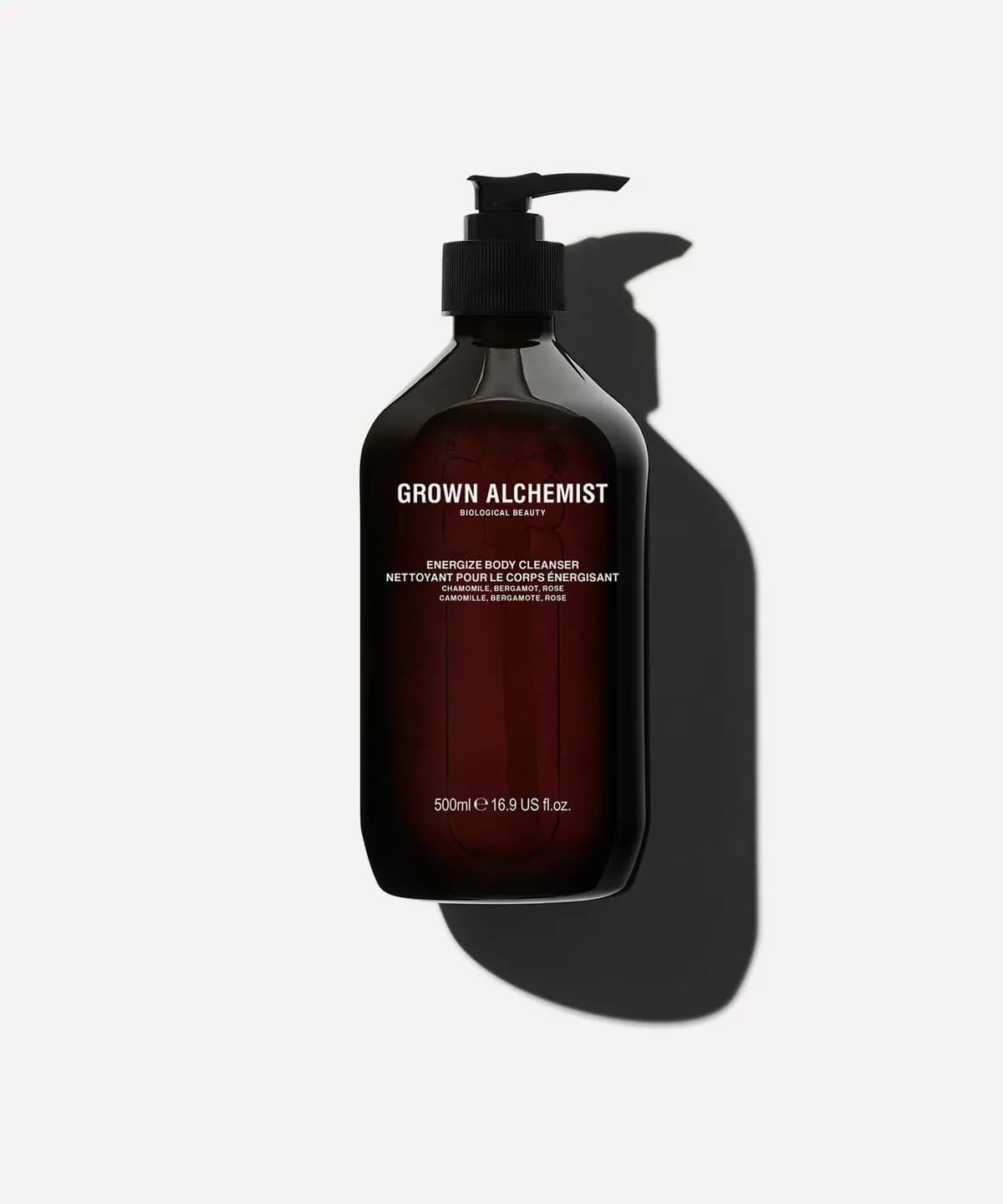 Grown Alchemist Energize Body Cleanser in a dark amber 500ml pump bottle casting a long shadow