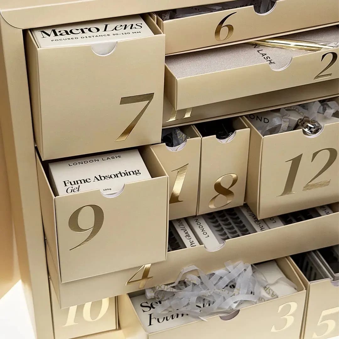 Close-up of opened calendar drawers revealing Macro Lens and Fume Absorbing Gel boxes inside numbered compartments