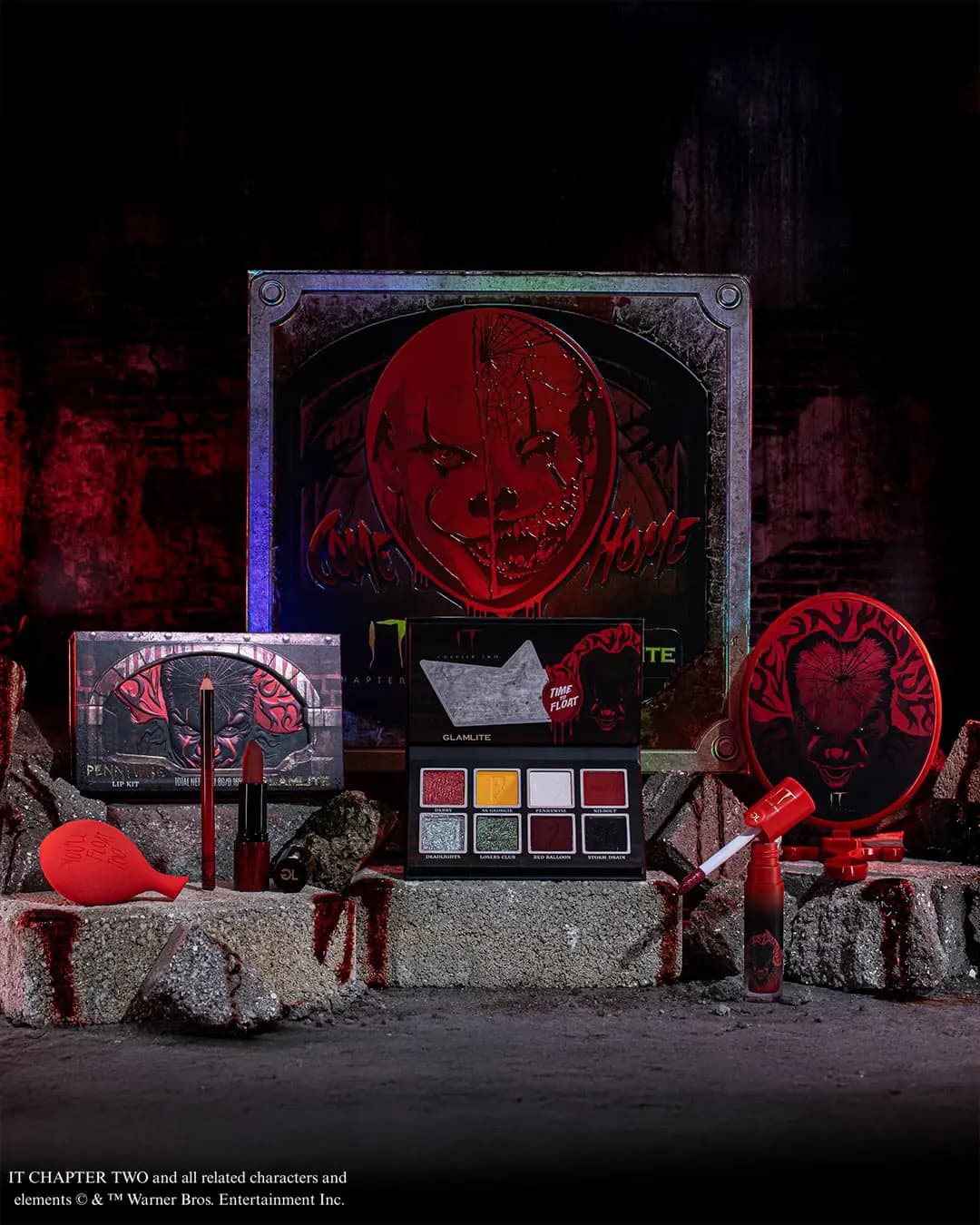 IT Chapter Two x Glamlite Collection with Come Home box, eyeshadow palette, lip kit, gloss, red sponge and mirror on rubble