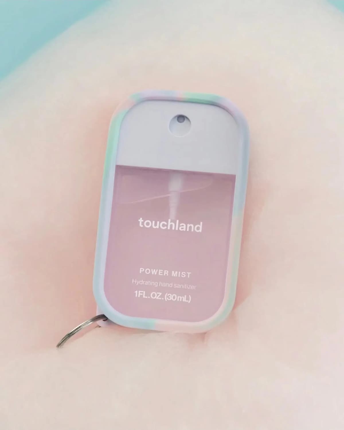 Touchland Power Mist hand sanitizer in pale pink with lavender cap and pastel marbled silicone case