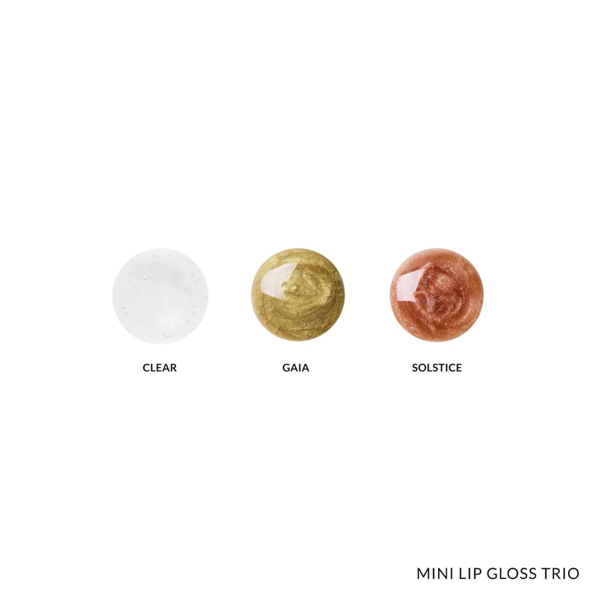 Round swatches of Clear, Gaia and Solstice glosses: transparent, shimmery green-gold and shimmery bronze