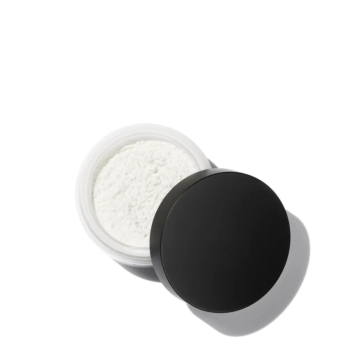 Open jar of fine white loose powder with the black lid resting beside it