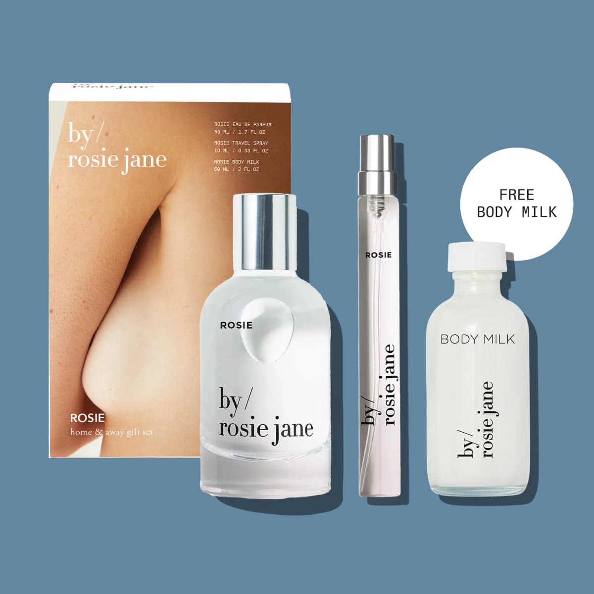Rosie home & away gift set box with eau de parfum, travel spray and Free Body Milk bottle on a blue background