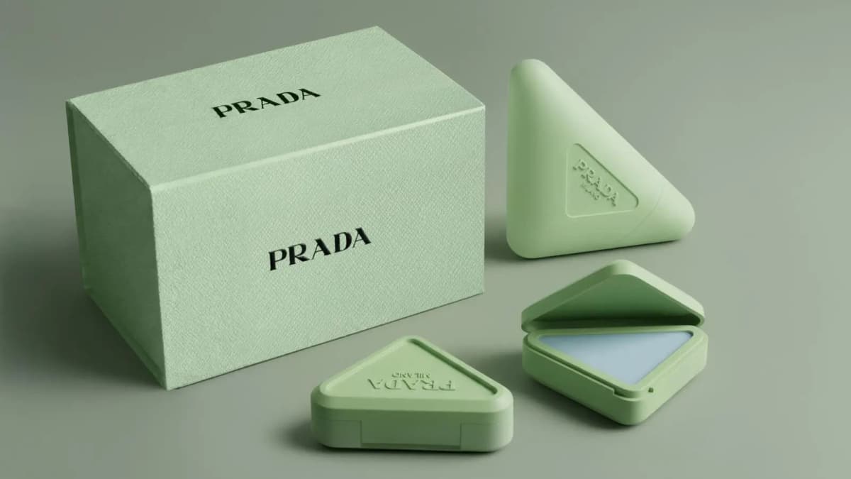 Mint-green textured Prada gift box with three triangular compacts, one open to show blue balm
