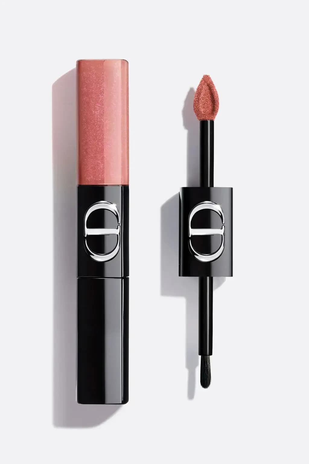 Black Dior liquid lip duo with a shimmering pink end, its doe-foot applicator and brush shown beside it