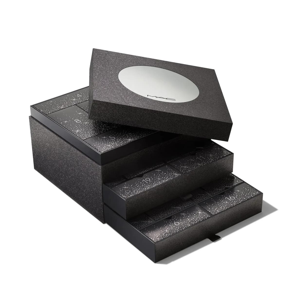 Closed black glitter calendar with lid lifted and two numbered drawers pulled out, on white