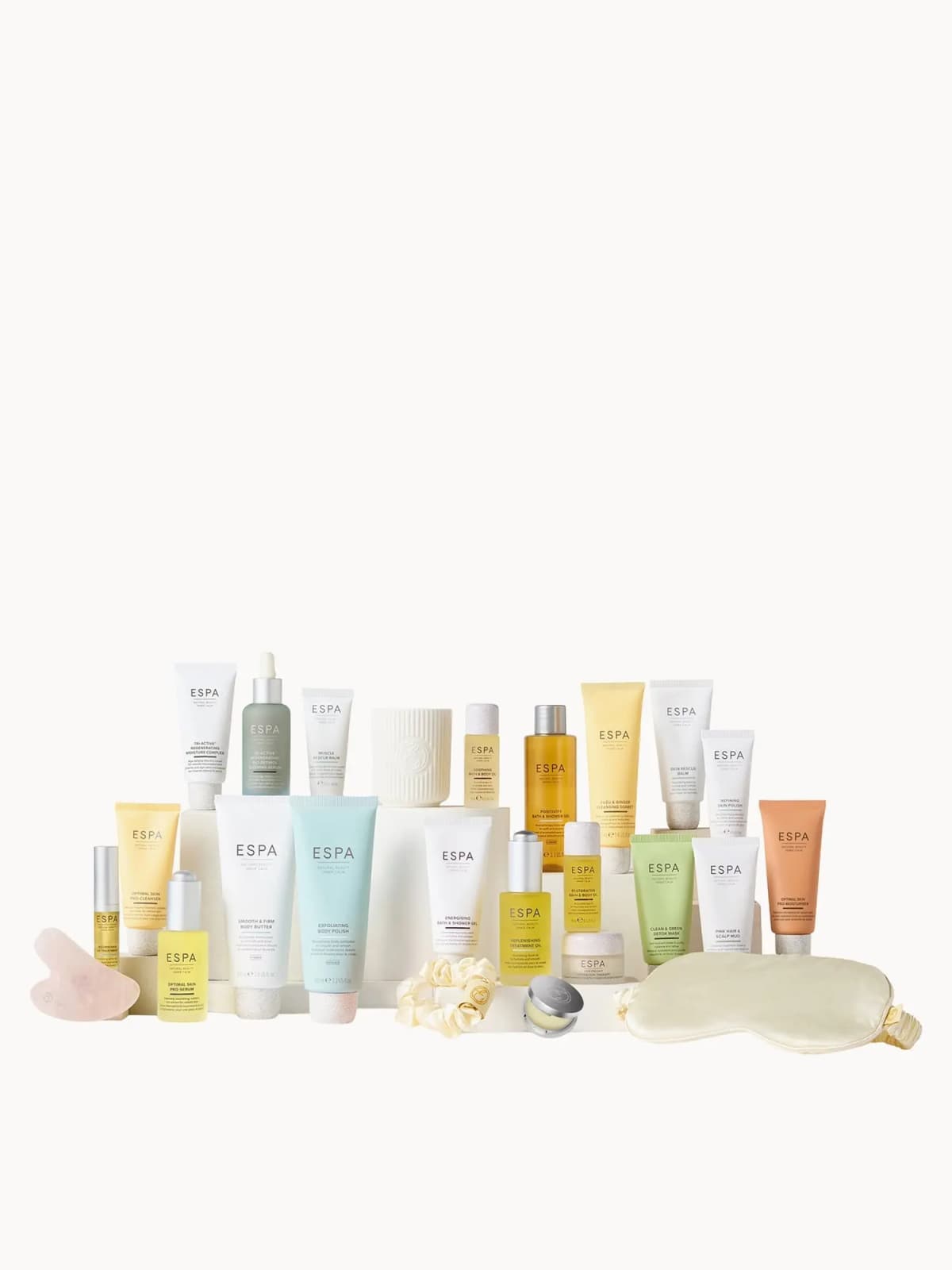 Full lineup of pastel tubes, oils, ribbed candle, rose quartz gua sha, cream silk eye mask and scrunchie