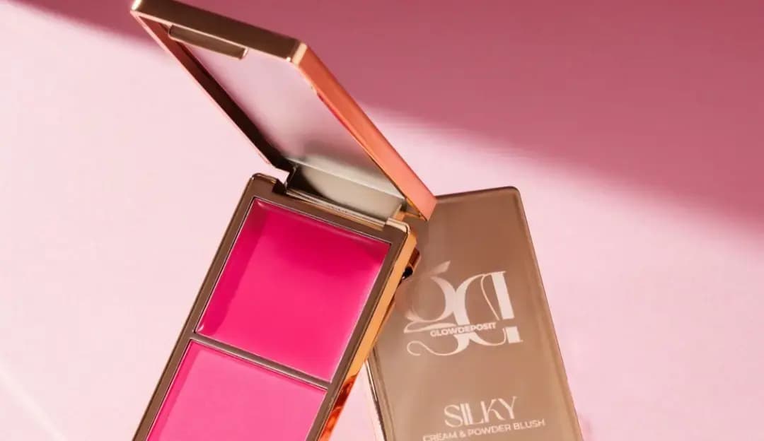Open compact with hot-pink cream and powder blush beside a gold Silky Cream & Powder Blush case on a pink backdrop