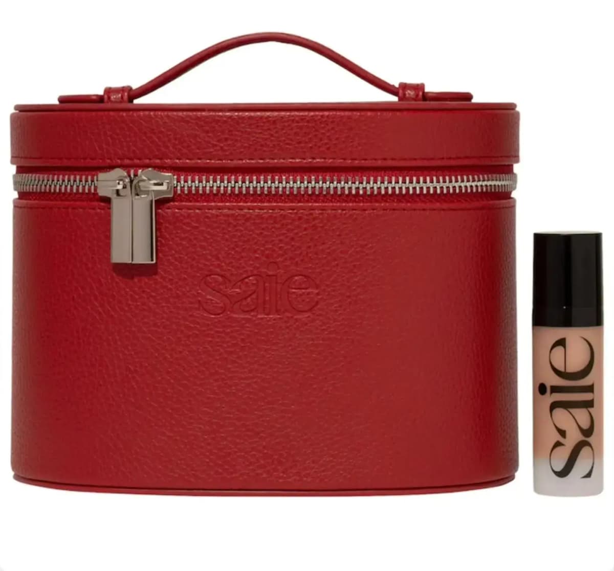 Red pebbled Saie vanity case with top handle and silver zip beside a mini frosted Saie bottle with black cap