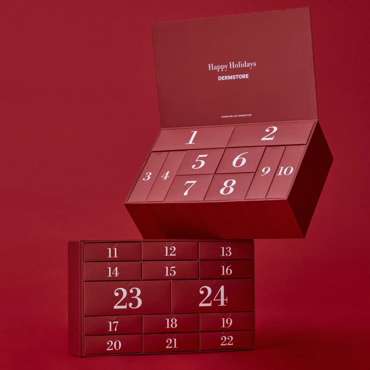 Dermstore advent calendar opened in two tiers, Happy Holidays lid above red drawers numbered 1 to 24