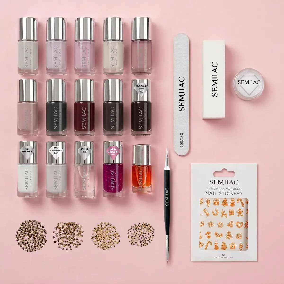 Flat lay of 15 Semilac polishes in nudes, darks and berry, plus nail file, buffer, glitter pot, studs