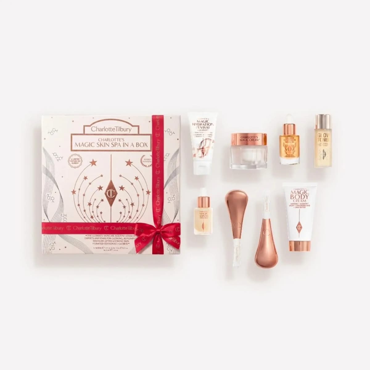 Charlotte's Magic Skin Spa in a Box with red ribbon, plus cleanser, Magic Cream, serums, Glow Toner and rose-gold ice globes