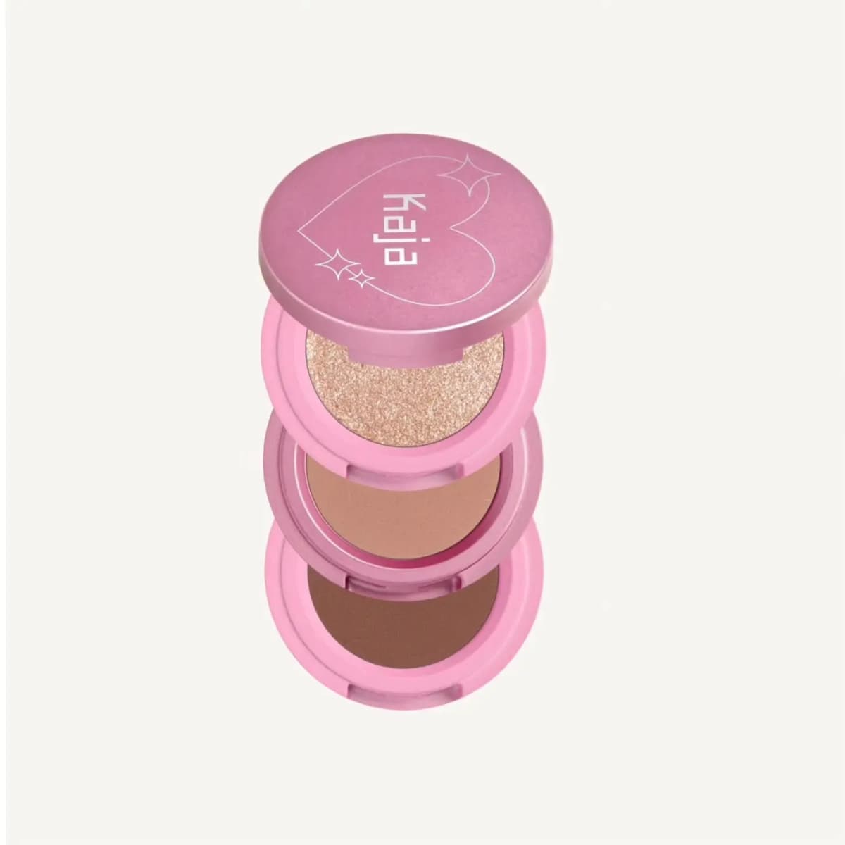 Kaja Beauty Bento stacked trio in pink compacts: shimmery champagne, matte taupe and matte chocolate brown shadows.
