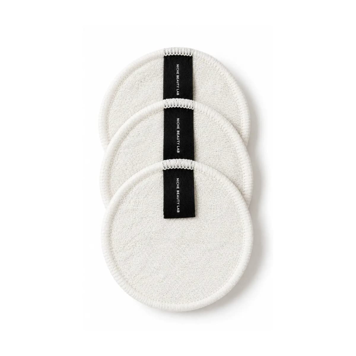 Three round white terry cotton reusable pads with black Niche Beauty Lab ribbon tabs