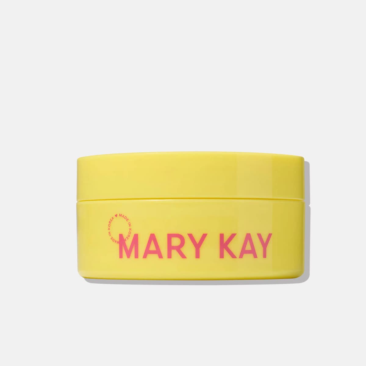 Wide yellow Mary Kay jar of face patches with pink logo and made in Korea mark on a grey background