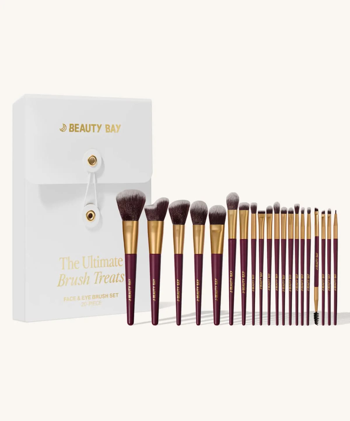 The Ultimate Brush Treats 20-piece face and eye brush set with burgundy and gold brushes beside a white case