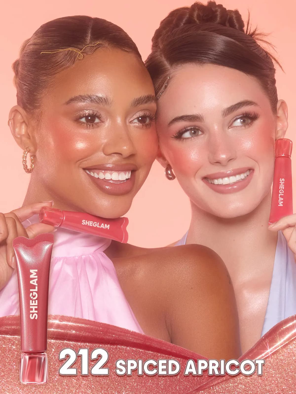 Two smiling models with coral-rose shimmery cheeks hold tubes, labelled 212 Spiced Apricot