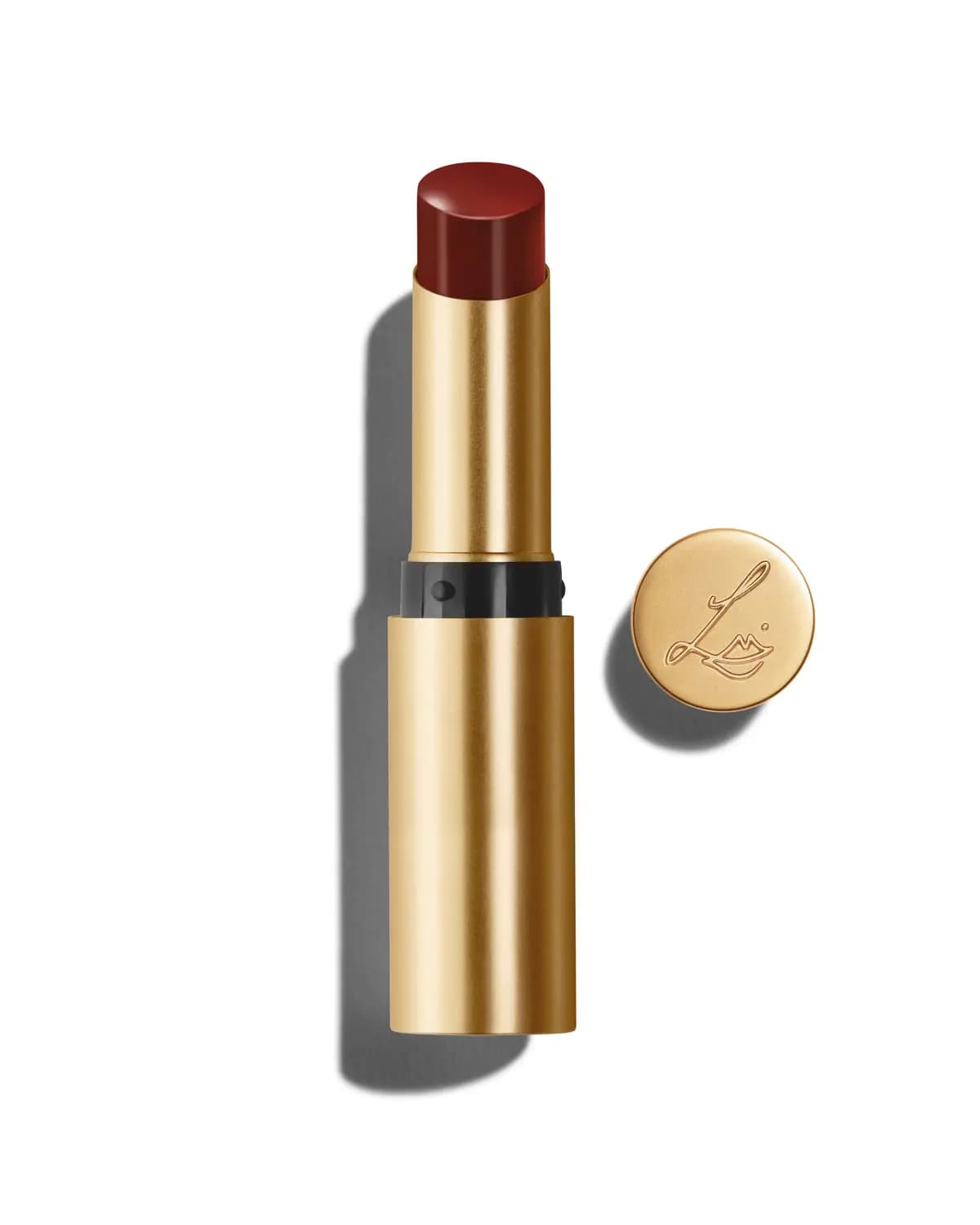 Deep red balm lipstick in a gold tube with its round gold cap embossed with the LE logo
