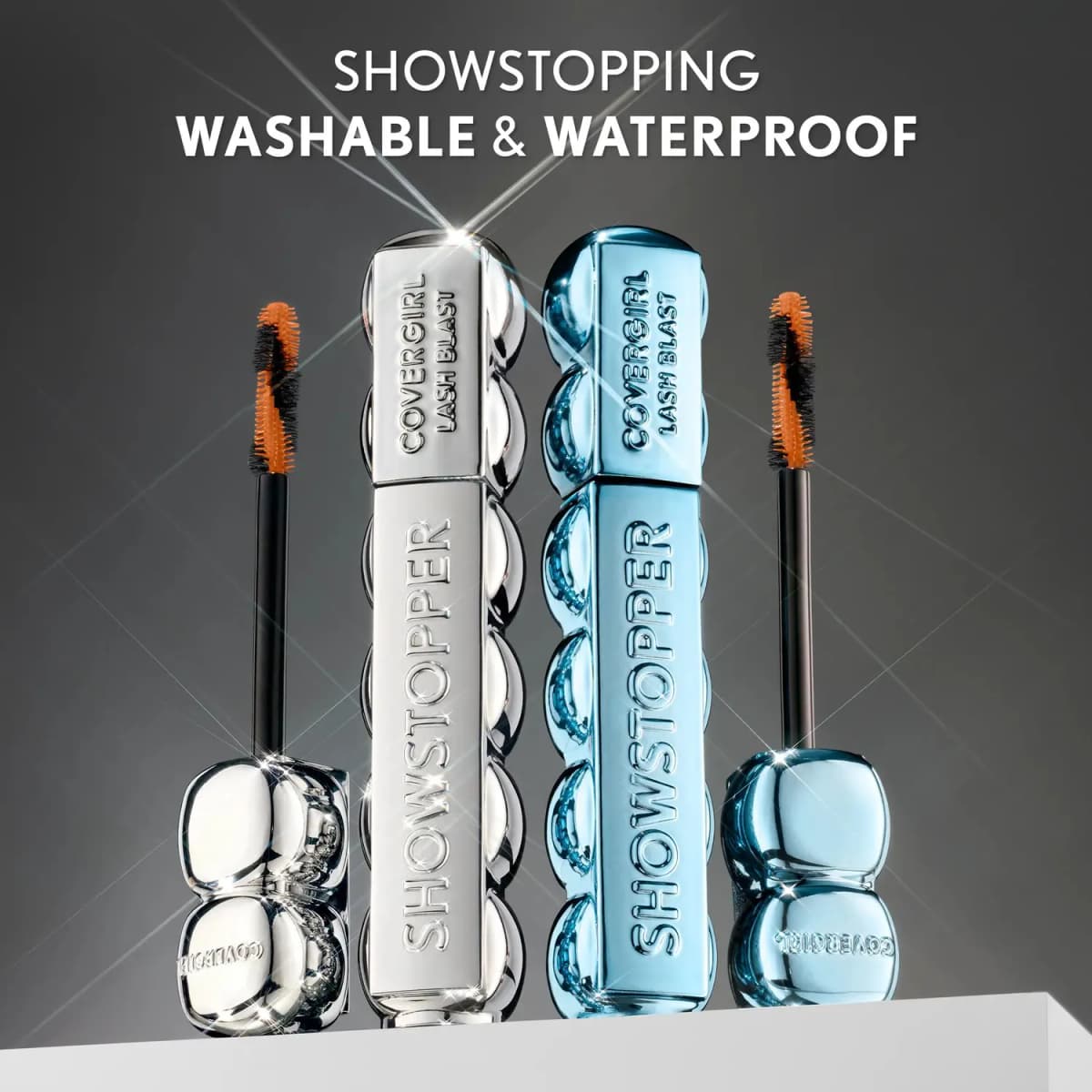 COVERGIRL Lash Blast Showstopper Mascara in chrome silver and waterproof blue tubes with orange-and-black brushes on a plinth