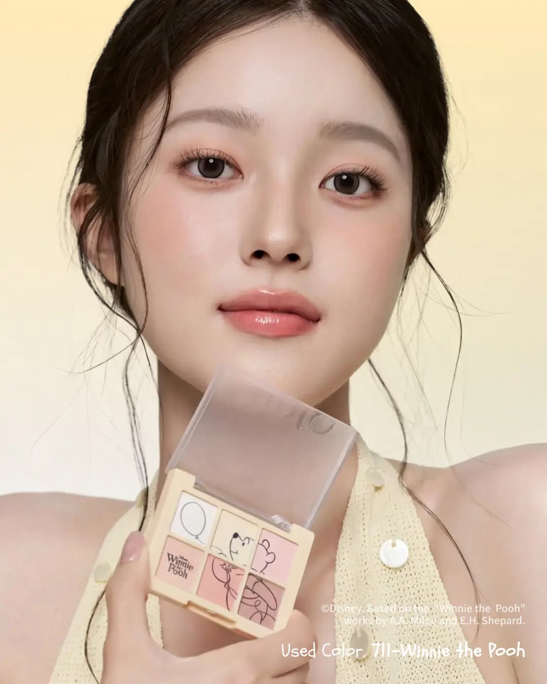 Model with soft peach eye makeup and glossy coral lips holds the open 711 palette near her chin