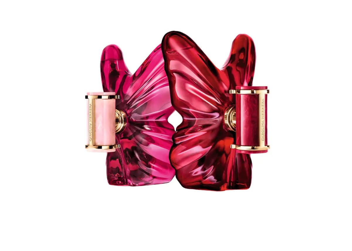 Pink butterfly bottle with pale pink cap facing a red butterfly bottle with red cap, both engraved Carolina Herrera