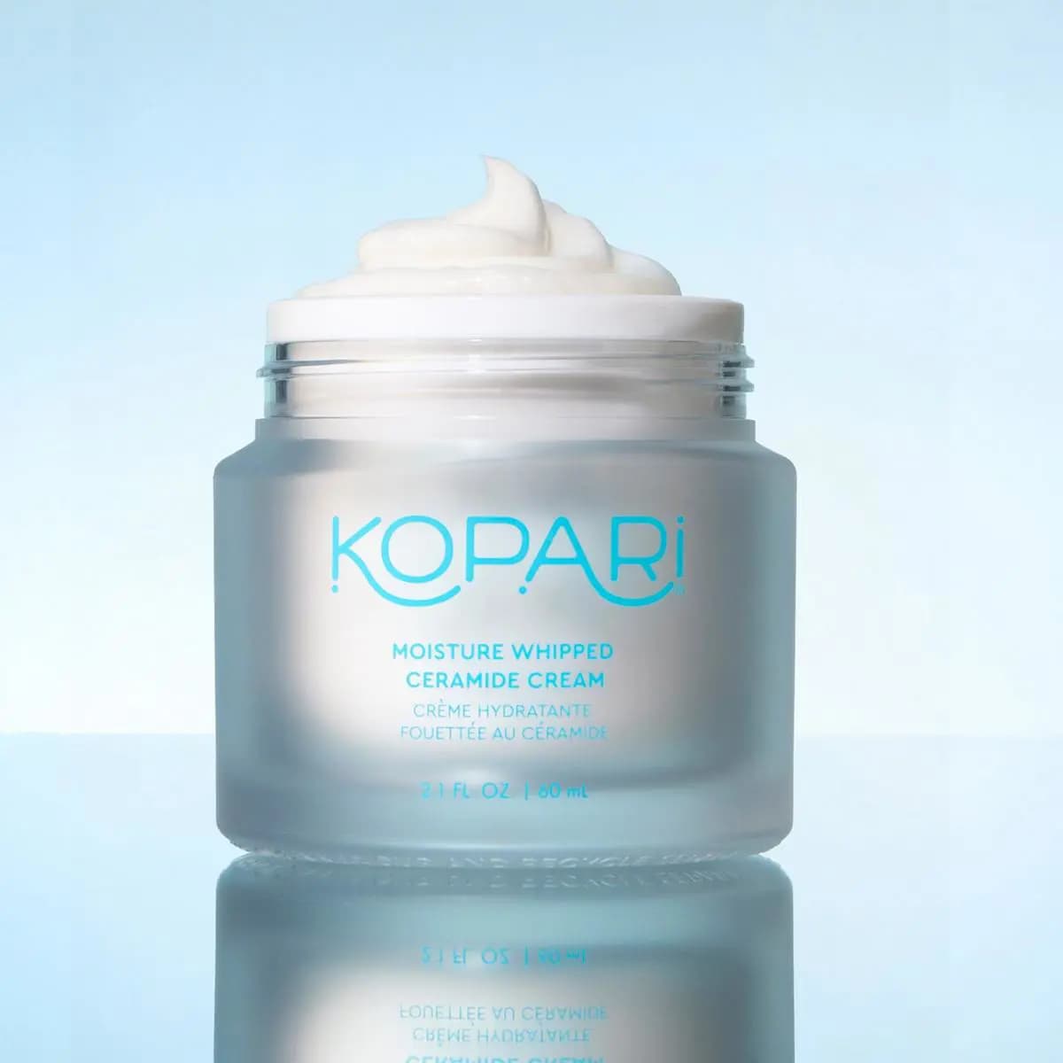 Frosted glass jar of Moisture Whipped Ceramide Cream, 60 mL, topped with a swirl of thick white cream
