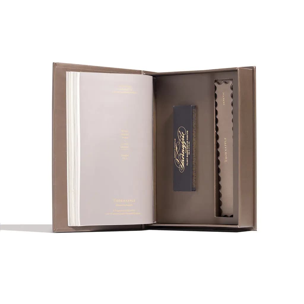 Open taupe book-box with a quote page on the left and the black Thornapple carton nestled in an inner tray.