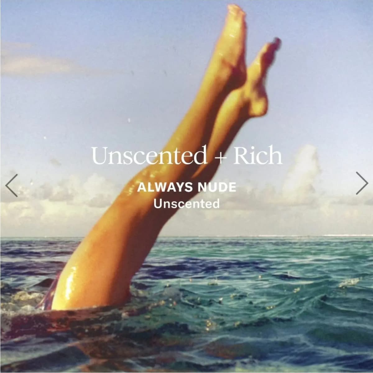 Bare legs rising out of turquoise ocean water under a blue sky, introducing the unscented Always Nude butter
