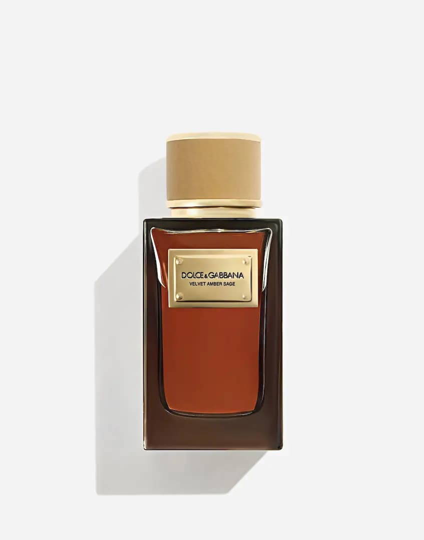 Rectangular smoky-brown bottle with amber-red juice, gold nameplate and tan velvet cap, front view on white