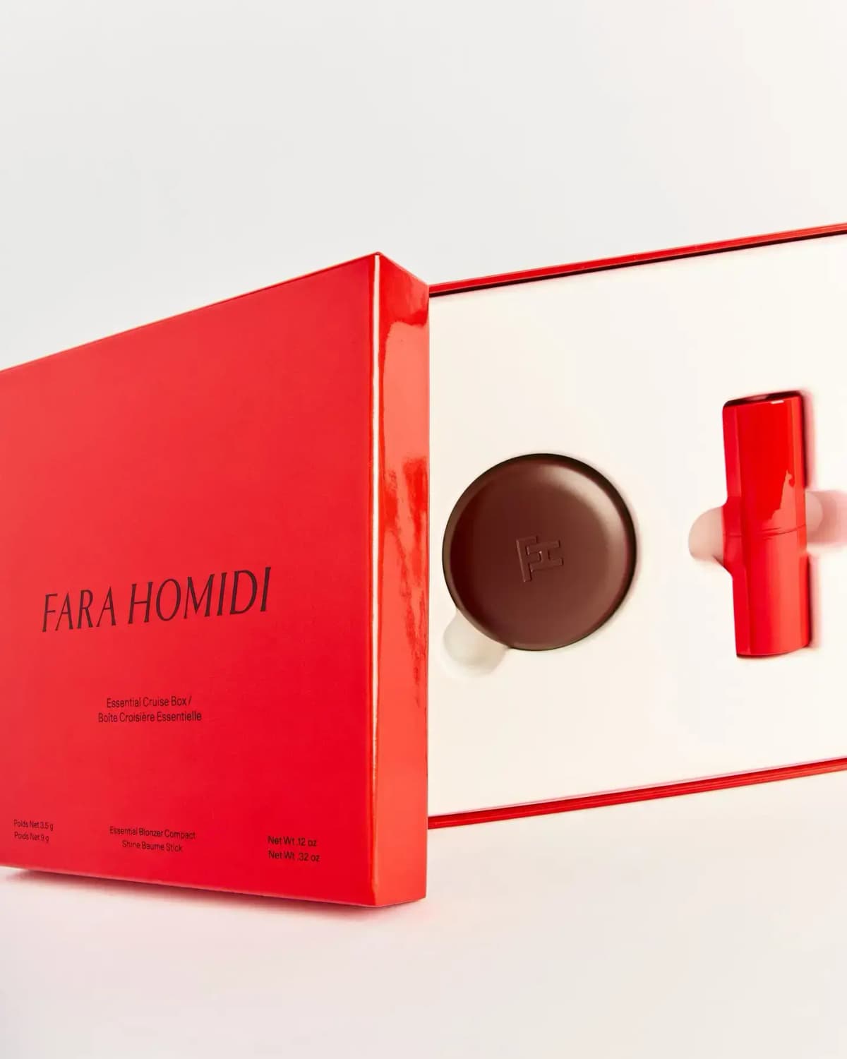 Glossy red Fara Homidi Essential Cruise Box sliding open to reveal a brown compact and red stick in a white insert
